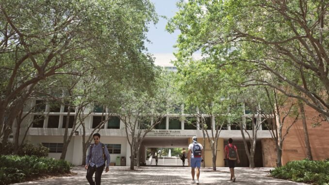 Students walking through a sunlit university campus in Coral Gables, Florida.