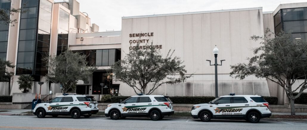 Sheriff vehicles parked in front of Seminole County Courthouse during the day.