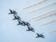 Aerial view of US Air Force Thunderbirds flying in formation against a blue sky.