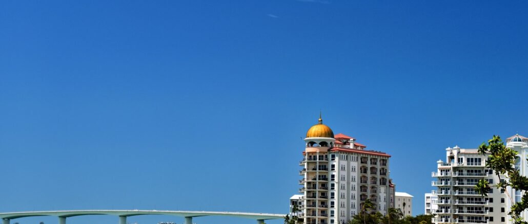Stunning waterfront view of Sarasota's skyline and bridge under a clear blue sky.