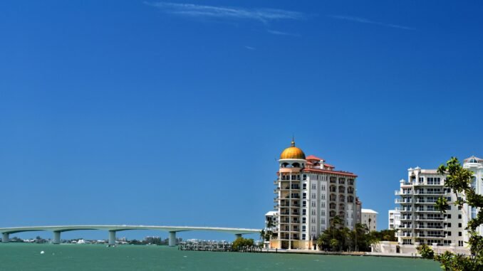 Stunning waterfront view of Sarasota's skyline and bridge under a clear blue sky.