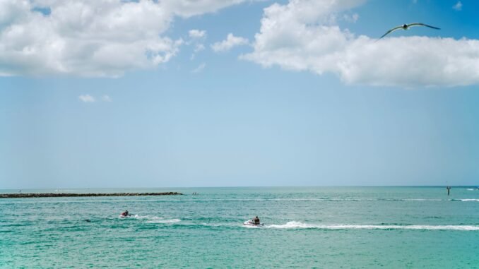 Experience a thrilling jetski ride under a bright sky on the vibrant blue waters of Clearwater Beach, Florida.